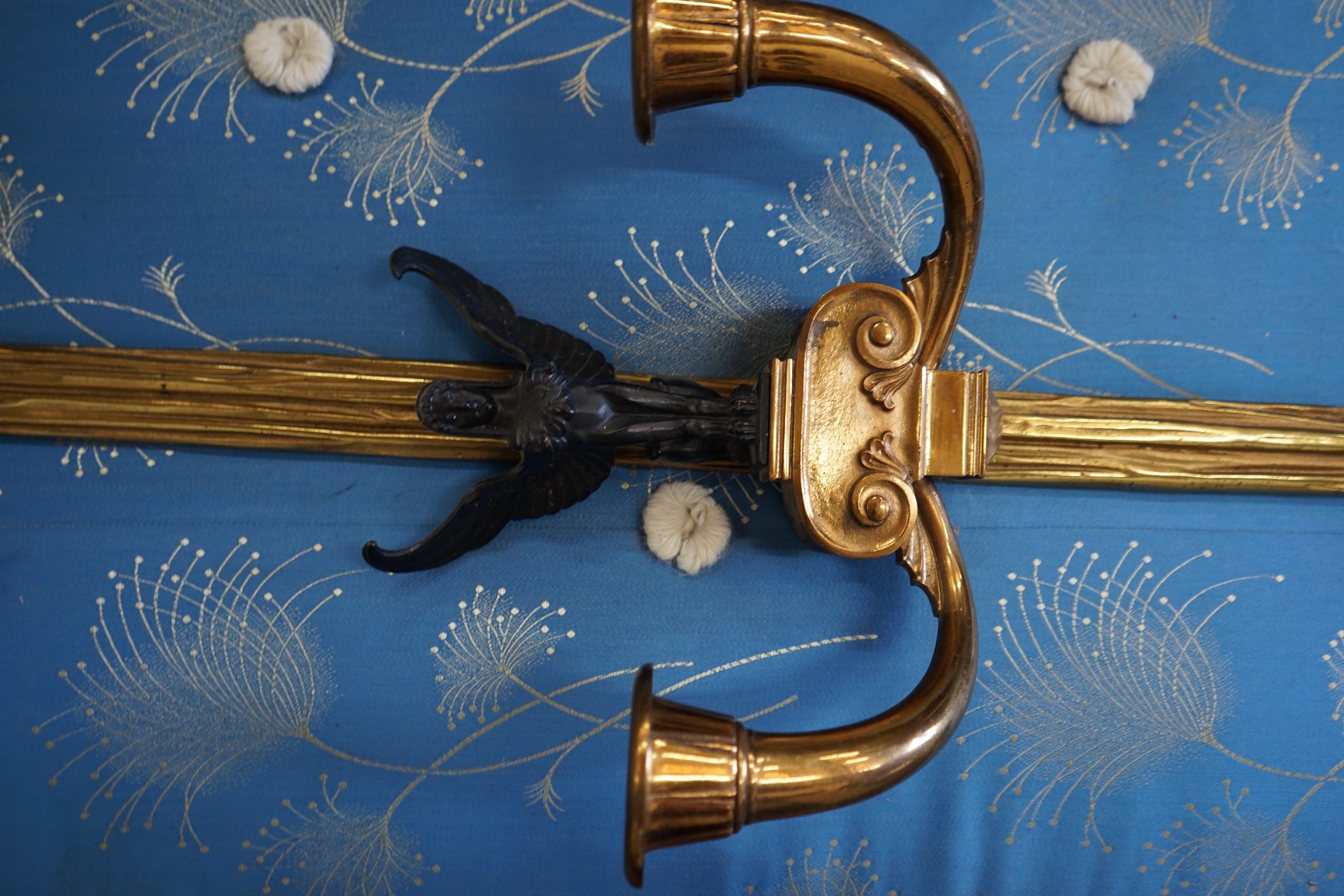 A pair of bronzed and gilt metal Empire style twin branch ribbon fold wall lights, height 95cm